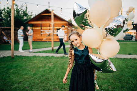 女孩在户外拿着气球。 生日生日生日