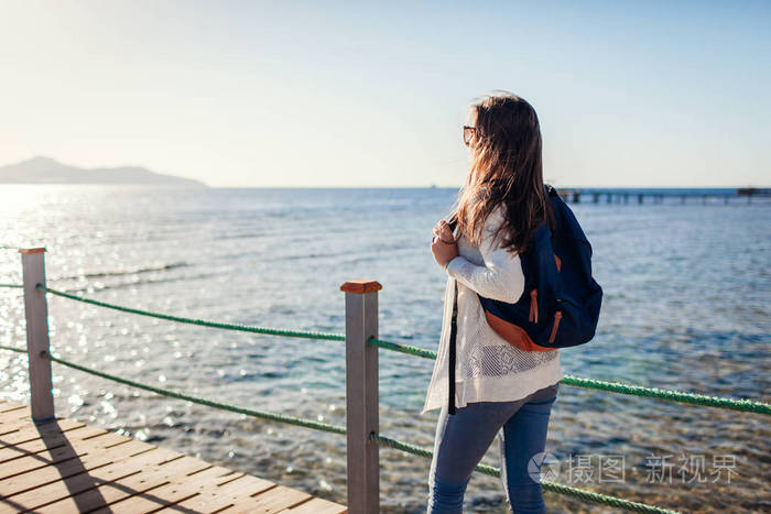年轻的女游客背着背包欣赏红海和蒂兰岛的风景,走在码头上. 旅行概念.