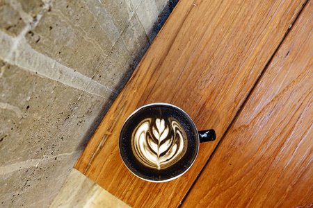 一杯木制背景的拿铁艺术咖啡