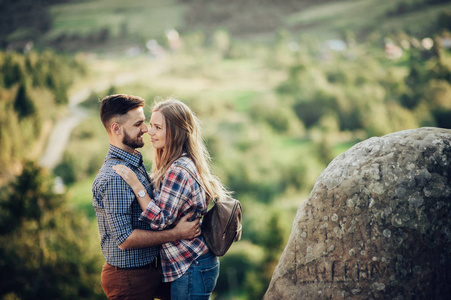一对年轻的幸福夫妇拥抱着夏天的山