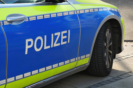 德国警车的侧视图,蓝色和黄色清漆在一个城市的人行道上照片