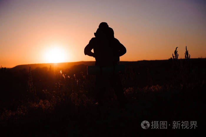 年轻人看着日落.背包旅行者