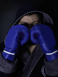 硬汉男拳击手在黑暗背景下摆出拳击姿势的肖像。 职业拳击手准备好参加拳击比赛。