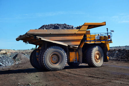 把煤装进车身工作卡车. 采矿车采矿机械从露天矿运输煤炭照片