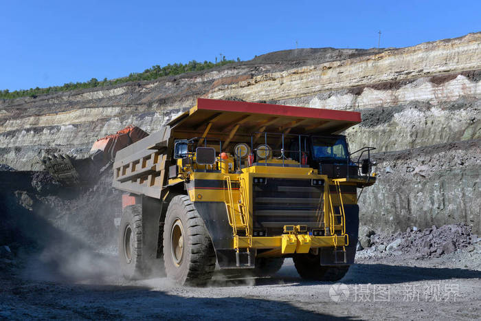 大型采石场自卸卡车把岩石装在翻斗车里把煤装进车身工作卡车采矿车