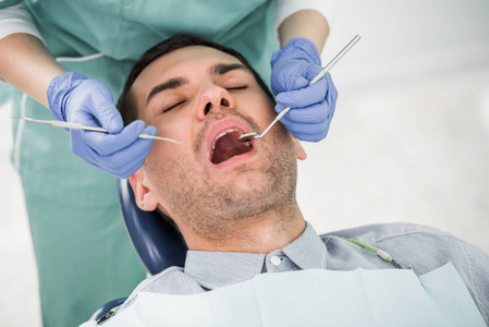 女性牙医与张口病人合作的剪影