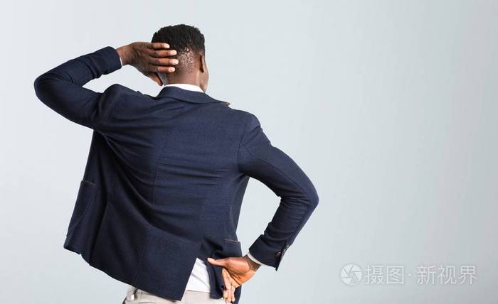 英俊的非裔美国男人穿着夹克背对着背部在孤立的灰色背景上挠头