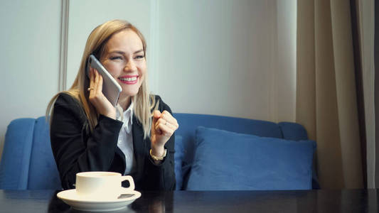 成功的女商人使用智能手机, 并在咖啡馆工作中获得晋升