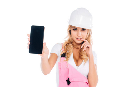 穿着粉红色工作服的方便女士站着，拿着智能手机，空白屏幕隔离在白色上