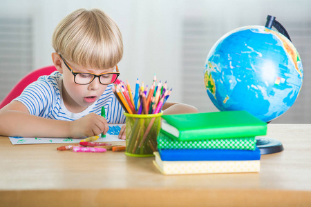 孩子学累了。不快乐的学生。精疲力尽的小男孩。教室里的男孩。做作业的孩子。