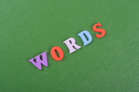 绿色背景上的单词由五颜六色的ABC字母组成，木制字母，广告文本的复制空间。学习英语
