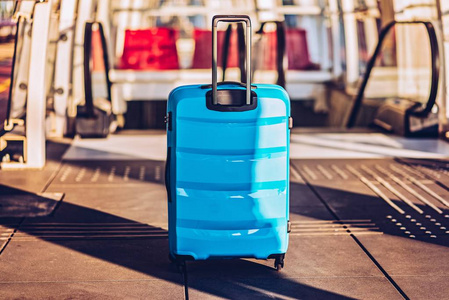 扶梯上蓝色行李箱..旅行概念