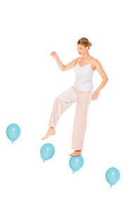 穿着睡衣的女孩漂浮在空中，站在白色上孤立的气球上
