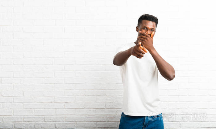黑皮肤男人用手指指着某人,捂着嘴笑了很多照片-正版商用图片18xu8f