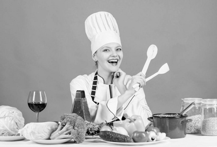 女性厨师烹饪健康食品。美食主菜食谱。烹饪是她的爱好。戴帽子和围裙的女孩美味的食谱概念。烹饪健康食品。烹饪餐用新鲜蔬菜食材