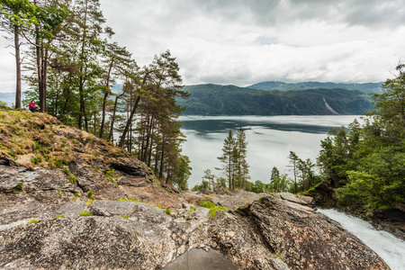 女游客享受峡湾景观，从Svandalsfossen瀑布地区的阴天景观。 挪威风景。 国家旅游路线。