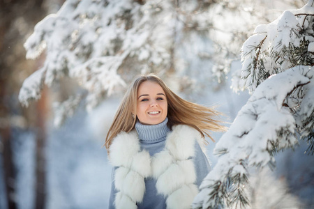 阳光明媚的冰冻天，白雪森林中美丽的年轻女子的户外肖像。