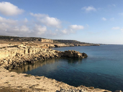 在塞浦路斯海岸一个受欢迎的地方的岸边，穿着粉红色T恤的浅肤色年轻女子