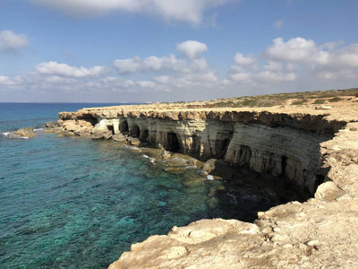 在塞浦路斯海岸一个受欢迎的地方的岸边，穿着粉红色T恤的浅肤色年轻女子