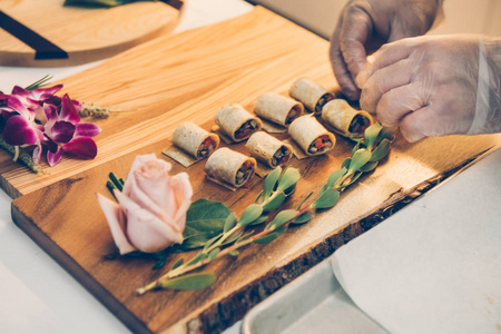 首席设计师设计的食品开胃菜在木制托盘上，甚至餐饮服务