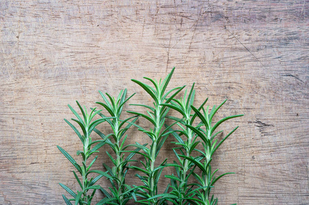 从上面的新鲜有机草本植物的木制乡村餐桌上的迷迭香植物，有文本的复制空间