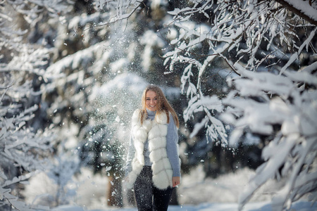 阳光明媚的冰冻天，白雪森林中美丽的年轻女子的户外肖像。