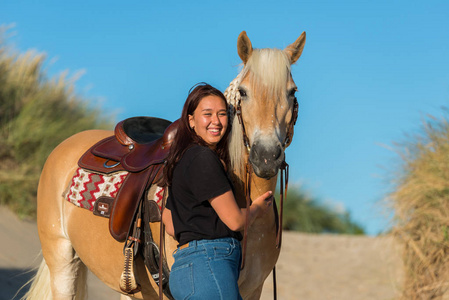十八岁的夏天女孩与马摆姿势在沙丘照片