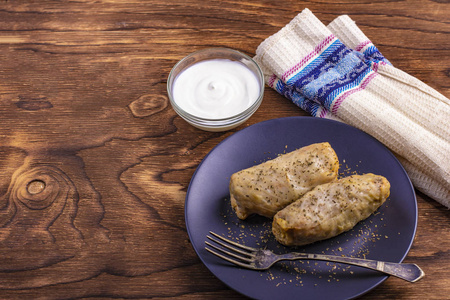 热白菜卷与米饭肉与酸奶油在一个粘土盘。 凯莱姆多马西填充卷心菜叶。在阿塞拜疆全年都是卷心菜