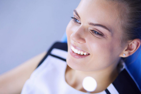 年轻女性患者与美丽的微笑检查牙科检查在牙医办公室