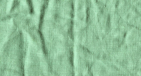 绿色织物表面为背景。 绿色亚麻布纹理。 绿色亚麻背景
