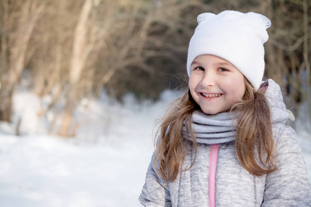 一个美丽的小女孩在冬季公园的肖像