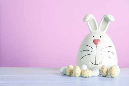 装饰兔子和复活节鸡蛋在桌子上的颜色背景。 文本空间