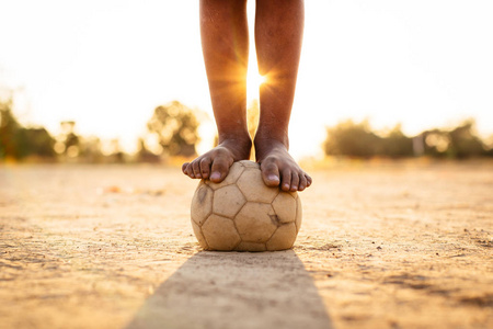 日落下，一群孩子在社区农村地区踢足球锻炼身体的动作体育图片。