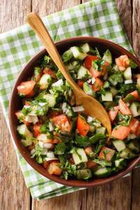沙拉的新鲜蔬菜和草药特写在盘子上的桌子上。阿博夫的垂直俯视图