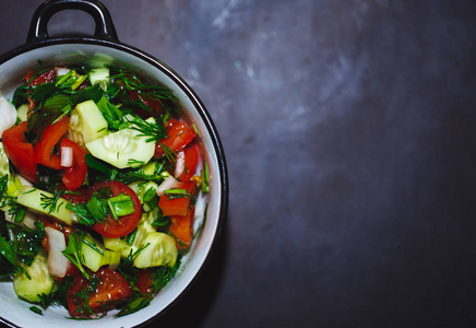 把新鲜西红柿和黄瓜的色拉收起来。健康食品，蔬菜..复制空间。