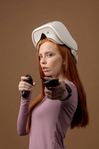 快乐的年轻红头发的女人使用虚拟现实耳机