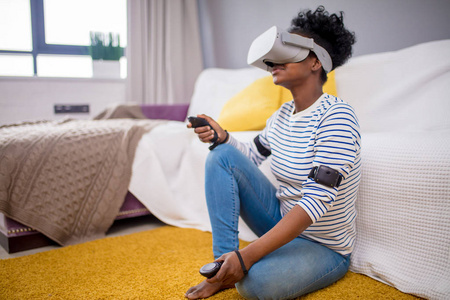 非洲妇女在家中使用带有遥控器的 vr 眼镜观看视频照片
