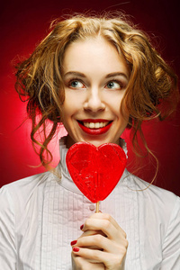 女人用焦糖在红色背景的心