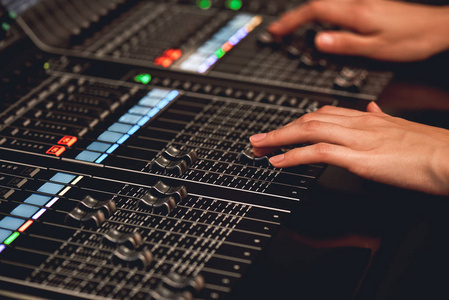 声音工程师调整数字音频混合控制台的特写视图.录音工作室照片