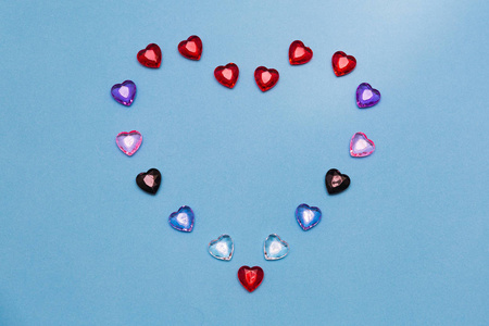 一颗由蓝色背景上的小多色玻璃心组成的大心脏.照片