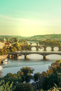 在日落下伏尔塔瓦河畔的捷克查尔斯桥和布拉格老城的景色