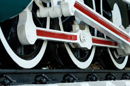 列车的特写车轮。 绿色的红白火车。 古董老式火车机车。 旧蒸汽机机车。 黑色机车。 旧的交通工具。
