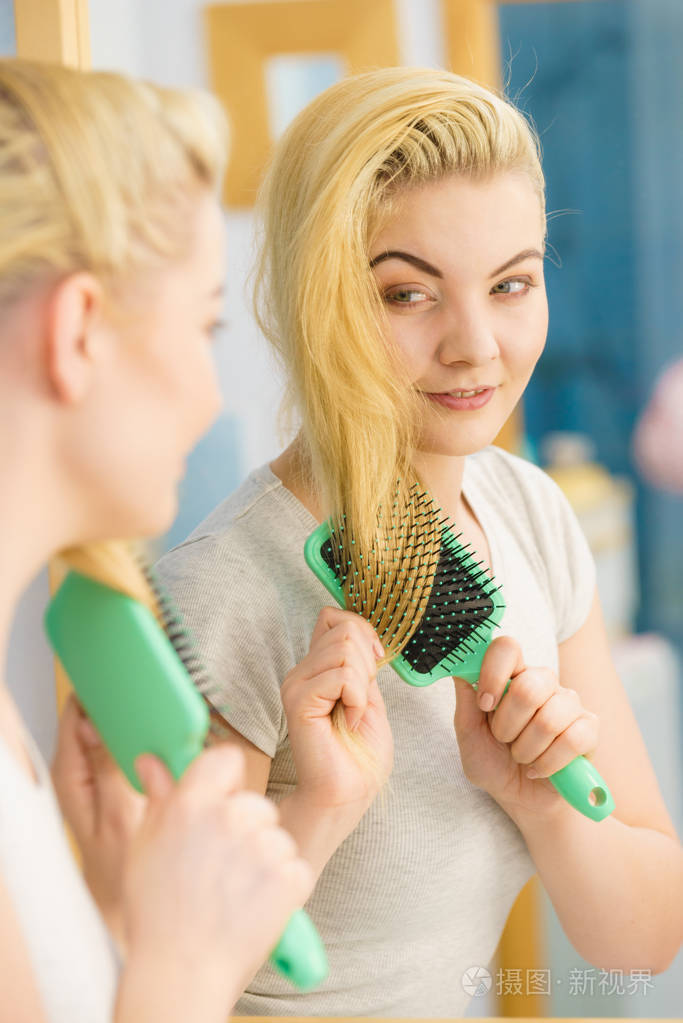 快乐的女人用刷子梳头发.
