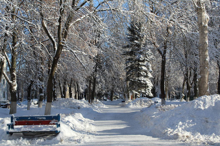 雪覆盖的小巷在城市照片小巷在城市。冬季。大量的雪。白天是阳光明媚的天空是蓝色的。在寒冷的霜雪季节，美丽的城市景观。