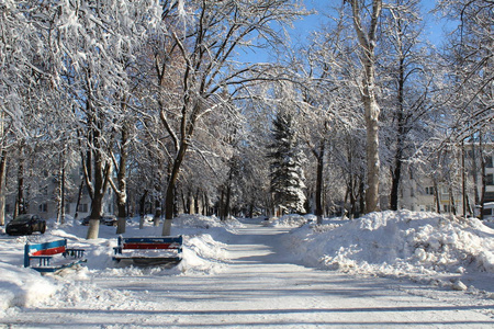 雪覆盖的小巷在城市照片小巷在城市。冬季。大量的雪。白天是阳光明媚的天空是蓝色的。在寒冷的霜雪季节，美丽的城市景观。