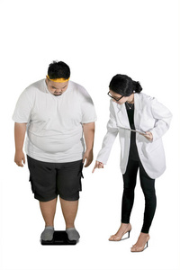 女医生的肖像，通过在工作室中用白色背景隔离的天平检查她肥胖的病人