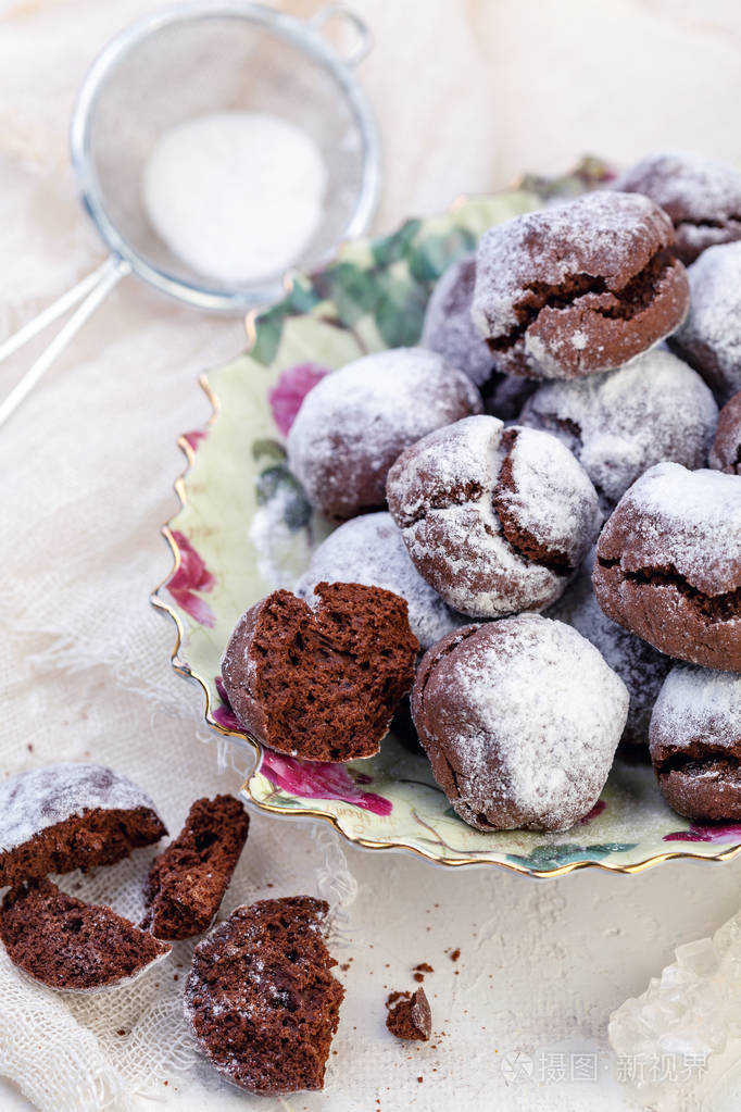 巧克力布朗尼饼干,撒上粉状糖和一个过滤器与粉状糖在白色纹理的桌子