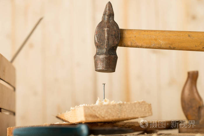 大钉子一个戴着白手套的人正在用黑色背景敲打桌子上
