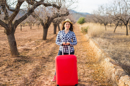 旅游, 旅游和人的概念快乐的年轻女子去旅行与红色手提箱和微笑的性质