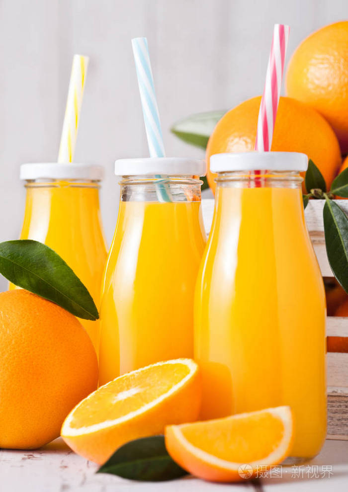 白色木箱中装有生橙的有机新鲜橙汁玻璃瓶